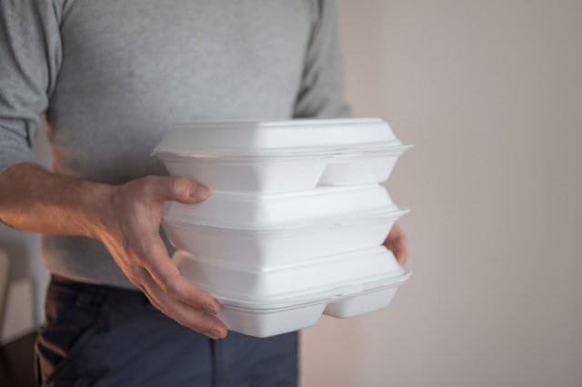 3つの弁当箱を運ぶ男性